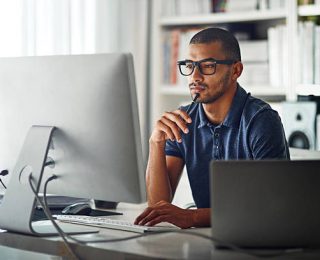 Cropped shot of a businessman using his computer in his home office