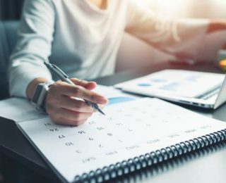 Business woman sitting working and thinking to planner event with calendar and laptop, computer on table at office or home or internet cafe.